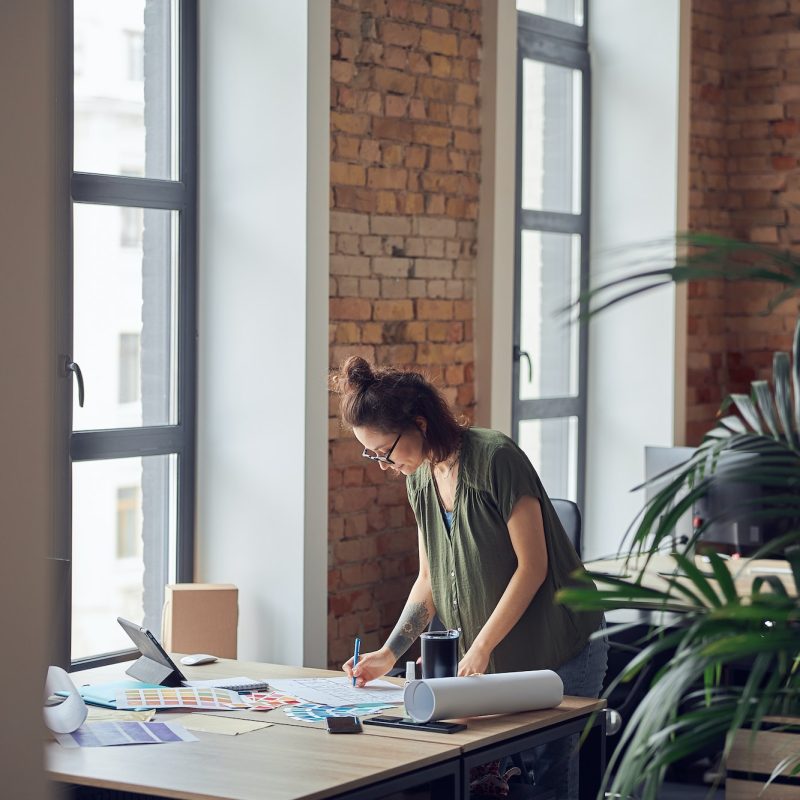 interior-designer-or-architect-in-casual-wear-with-messy-hairdo-looking-focused-while-working-on.jpg